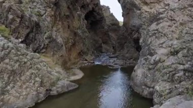 Seyahat et ve keşfet. Uçurumlardaki bir nehri takip eden hava görüntüsü. Kayalık kanyon boyunca akan suyun görüntüsü. Kaya duvarı ve uçurum farklı dokular yaratır..