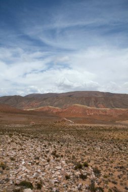 Çölün arka planında. Renkli kanyon, kumtaşı ve kayalık dağlar güzel bir gökyüzünün altında.