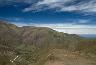 Manzaralı bulutlu mavi gökyüzünün altındaki güzel dağların manzarası.      