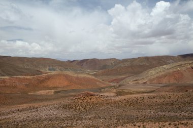 Manzaralı bulutlu mavi gökyüzünün altındaki güzel dağların manzarası.      