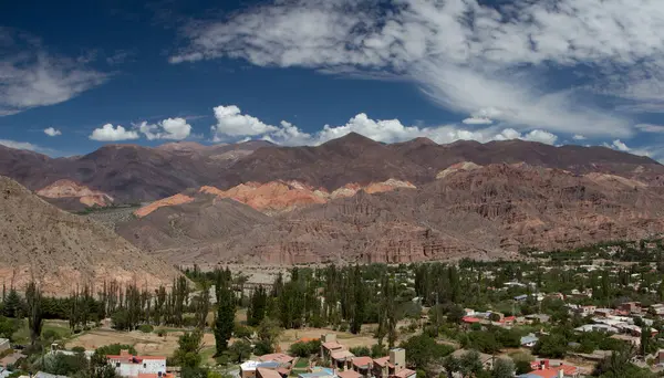 Stock image Altiplano landscape. Tilcara village at the foot of Humahuaca ravine in Jujuy, Argentina. Panorama view of the colorful mountains and town buildings under a beautiful sky with clouds.