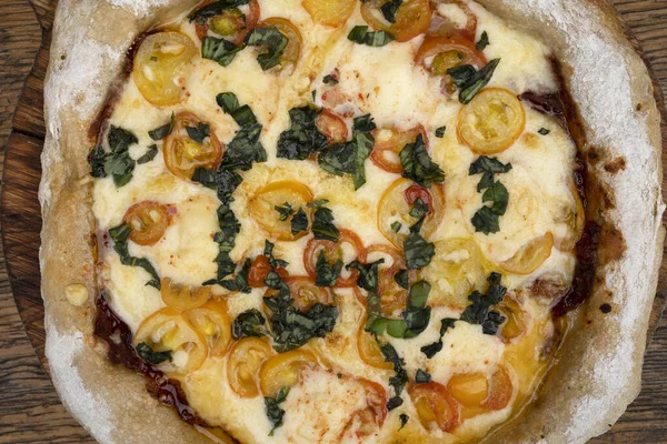 stock image Closeup view of a pizza with mozzarella and provolone cheese, garlic and cherry tomatoes.  