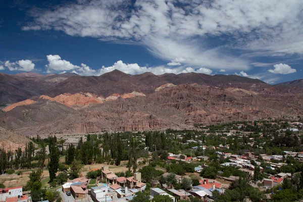 stock image Altiplano landscape. Tilcara village at the foot of Humahuaca ravine in Jujuy, Argentina. Panorama view of the colorful mountains and town buildings under a beautiful sky with clouds.
