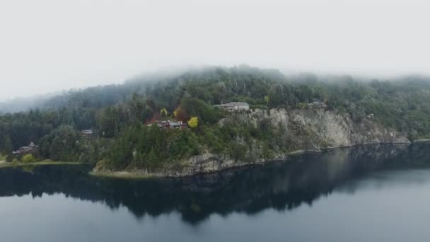 霧と早朝の湖や森の空中ビュー 海岸線 岩の崖や森の中の家のビュー 水面に映る美しい風景 — ストック動画