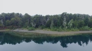 Sabahın erken saatlerinde sisli göl manzarası. Güzel orman ve bulutlu gökyüzü yansıması su yüzeyinde.