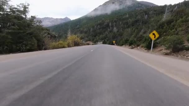 湖のほか 曇りの日に森や山を越えてアスファルトの高速道路に沿って車の運転の視点 — ストック動画