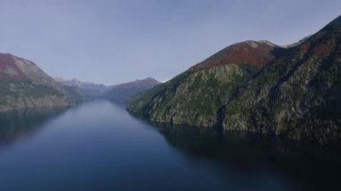Bariloche, Patagonya 'daki Llao Llao tepesindeki Nahuel Huapi gölünün üzerinde uçuyor. Mavi gölün, ormanın ve dağların havadan görünüşü ve mavi sulardaki manzara yansıması..