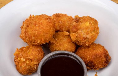 Beyaz kasede baharatlı soslu kızarmış tavuk toplarının yakın görüntüsü..