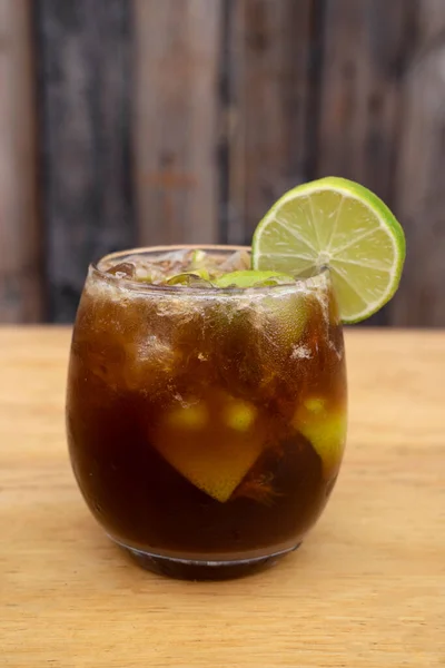 鸡尾酒 用Jgerinha 冰块和石灰 木制背景的酒精饮料 — 图库照片