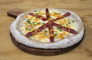 Mozzarella peyniri, füme sosis, yeşil soğan ve çedar peyniri soslu pizzanın yakın görüntüsü.. 