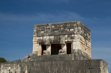 Turizm. Antik Maya kültürü ve medeniyeti. Meksiko 'daki Mayan şehri Chichen Itza' daki büyük top sahasındaki taş bina harabelerinin yakınında..