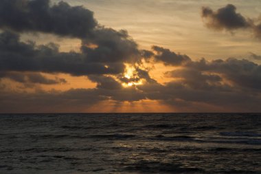 Tatiller. Deniz Burnu. Gün batımında gökyüzü, bulutlar, okyanus ve deniz dalgaları dramatik görünüyor. Güzel altın renkler. 