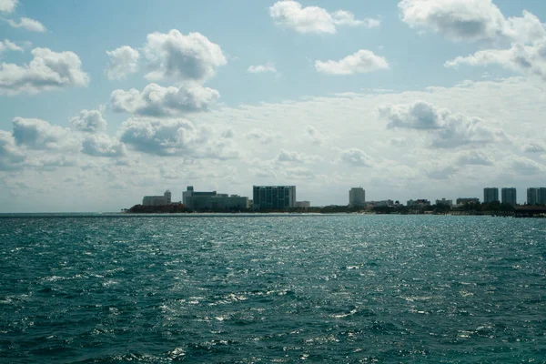 从一艘航行在绿松石色海水中的小船上眺望 蔚蓝的大海 海岸线和坎昆的城市建筑在地平线上 阳光明媚的夏日 — 图库照片