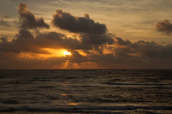 stock image Vacations. Seascape. Dramatic view of the sky, clouds, ocean and sea waves at sunset. Beautiful golden colors. 