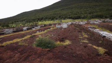 Çevresel hasar. Terk edilmiş doğal turba bataklık sömürüsü fabrikası manzarası. Ushuaia, Patagonya 'daki kırmızı yosun tarlası Sphagnum magellanicum, orman ve And Dağları, Arjantin.