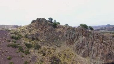 Vadiden ve dağlardan akan nehrin havadan görünüşü. Toprak yol manzarası, sarı çayır, tepeler ve Patagonya 'daki kayalık uçurum..