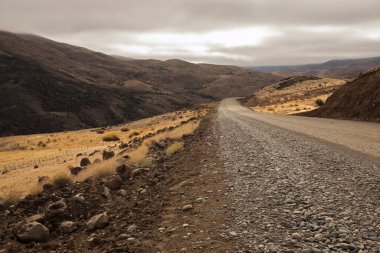 Seyahat et. Sonbaharda sarı çayırlarda ve dağlarda toprak yol.. 