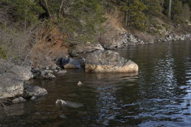 Göl manzarası, uçurumlar, kayalık sahil ve orman.. 