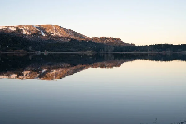 stock image View of the calm lake and mountains at sunset. Beautiful landscape and sky reflection in the water surface. 