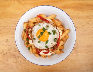 Izgara yumurtalı kızarmış patates, kavrulmuş kırmızı dolma biber, soğan ve krem peyniri beyaz kasede.. 