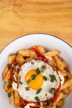 Izgara yumurtalı kızarmış patates, kavrulmuş kırmızı dolma biber, soğan ve krem peyniri beyaz kasede.. 