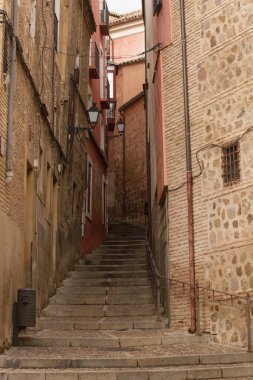 Mimarlık. Boş dar bir sokak. İspanya, Toledo 'daki ortaçağ şehri boyunca uzanan taş merdiven yolu.. 