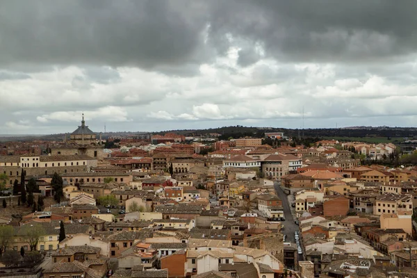 Şehir dokusu ve deseni. Şehir manzarası. İspanya, Toledo 'da bulutlu bir gökyüzünün altında ortaçağ ve Rönesans mimarisinin şehir binalarının manzarası.. 