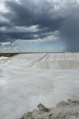 Endüstriyel Doğal beyaz tuz düzlükleri ve güzel bir gökyüzünün altında açık maden ocağı manzarası.