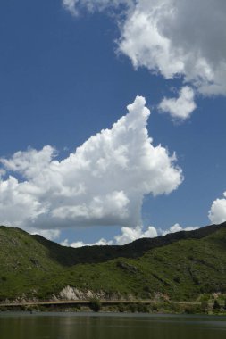 Güneşli bir günde göl, dağlar ve orman manzarası. 