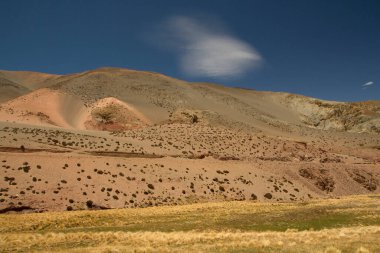 Doğal doku ve renkler. Kum tepelerinin güzel manzarası, dağlar, yeşil ve sarı çayırlar ve derin mavi gökyüzünün altındaki vadi. 