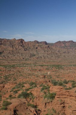 Dik kanyon. Kızıl çöl manzarası, uçurumlar, turuncu kumtaşı oluşumları ve ufuktaki kayalık dağlar San Luis, Arjantin 'deki Sierra de las Quijadas Ulusal Parkı.