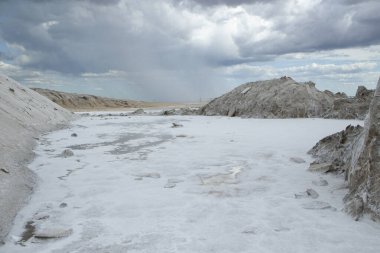 Doğal tuz düzlükleri. Endüstri ve açık döküm madencilik. Dramatik ve fırtınalı bir gökyüzü altında tuzlu ve doğal tarlalar.