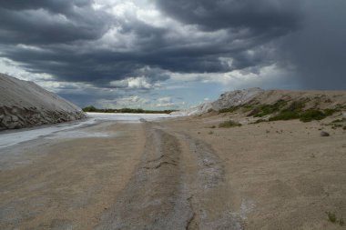 Doğal tuz düzlükleri. Endüstri ve açık döküm madencilik. Dramatik ve fırtınalı bir gökyüzü altında tuzlu ve doğal tarlalar.