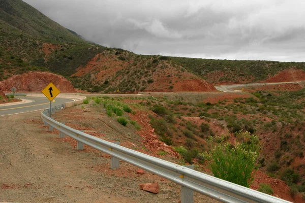 空旷的柏油路穿过红岩悬崖和群山 沿着阿根廷拉里奥哈的米兰达斜坡公路旅行 — 图库照片