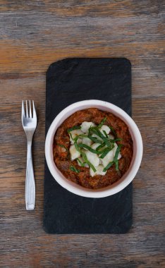 Geleneksel Macar yemeğinin en iyi manzarası, dana eti ve gnocchi ile gulaş güveci, restoranın ahşap masasında siyah bir tabakta..