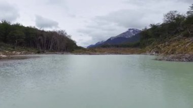 Ormandaki turkuaz bir buzulun ve gölün havadan görünüşü..