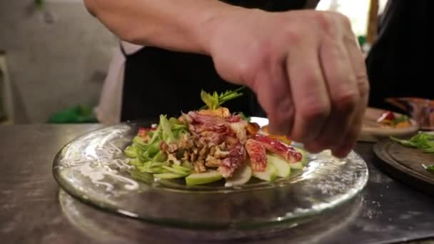 グルメ アジア料理 レストランキッチンで巨大なカニプレートを塩漬けする男性シェフの手のクローズアップビュー — ストック動画