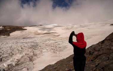 And Dağları kordillerasında yürüyüş. Cep telefonuyla fotoğraf çeken bir kadının görüntüsü. Buzul Castao Overo buz sahası ve Tronador tepesi kayalık dağ tepesi..