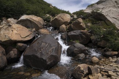 Kayalık dağ boyunca akan tatlı su akıntısının görüntüsü.