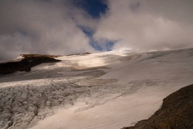 Alp manzarası. Andes Cordillera dağlarında. Bulutlu bir gökyüzünün altında Castano Overo ve Tronador tepelerinin manzarası. Güzel beyaz kar renkleri ve buz dokusu.