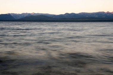 Gün batımında Nahuel Huapi Gölü ve And Dağları 'nın uzun pozlu görüntüleri. Güzel bulanık su efekti ve alacakaranlık rengi.