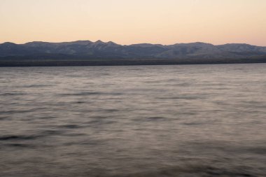 Gün batımında Nahuel Huapi Gölü ve And Dağları 'nın uzun pozlu görüntüleri. Güzel bulanık su efekti ve alacakaranlık rengi.