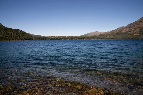 Bariloche, Patagonya, Arjantin 'deki Gutierrez Gölü manzarası. Turkuaz su, kayalık sığlıklar ve ufuktaki dağlar..