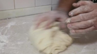 Adam mutfakta hamur yoğuruyor.