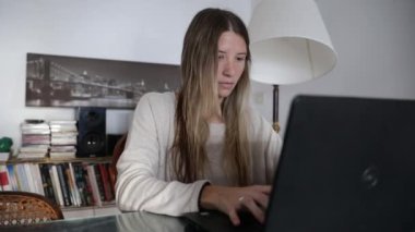 İletişim. Modern. Yaşam tarzı. Evden çalışıyorum. Evden çalışan, klavyeye yazı yazan ve ekrana bakan beyaz bir kadının yavaş çekim görüntüsü..