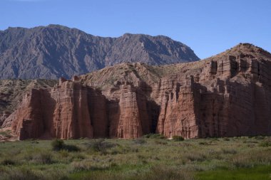 Jeoloji. Vadinin panorama manzarası, çayırlar, dağlar, kızıl kayalar ve Arjantin, Salta 'daki Kaleler adı verilen kumtaşı tepesi..