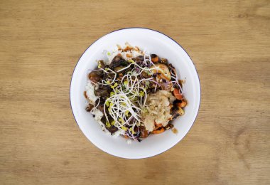 Vejetaryen mutfağı. Glütensiz. Restorandaki ahşap masada ızgara tofu, soya lahanası, balkabağı tohumu, mevsim sebzesi, baharatlı mango, suşi pilavı, salatalık ve kimchi ile en iyi manzara..