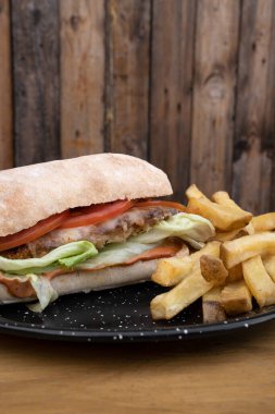 Bitki bazlı vejetaryen yiyecekler. Etli, marullu, mozzarella peynirli, domatesli ve patates kızartmalı sandviçin yakından görüntüsü..