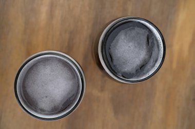 İçkiler. Tahta masadaki iki bardak biranın üst görüntüsü..