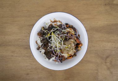 Vejetaryen mutfağı. Glütensiz. Restorandaki ahşap masada ızgara tofu, soya lahanası, balkabağı tohumu, mevsim sebzesi, baharatlı mango, suşi pilavı, salatalık ve kimchi ile en iyi manzara..